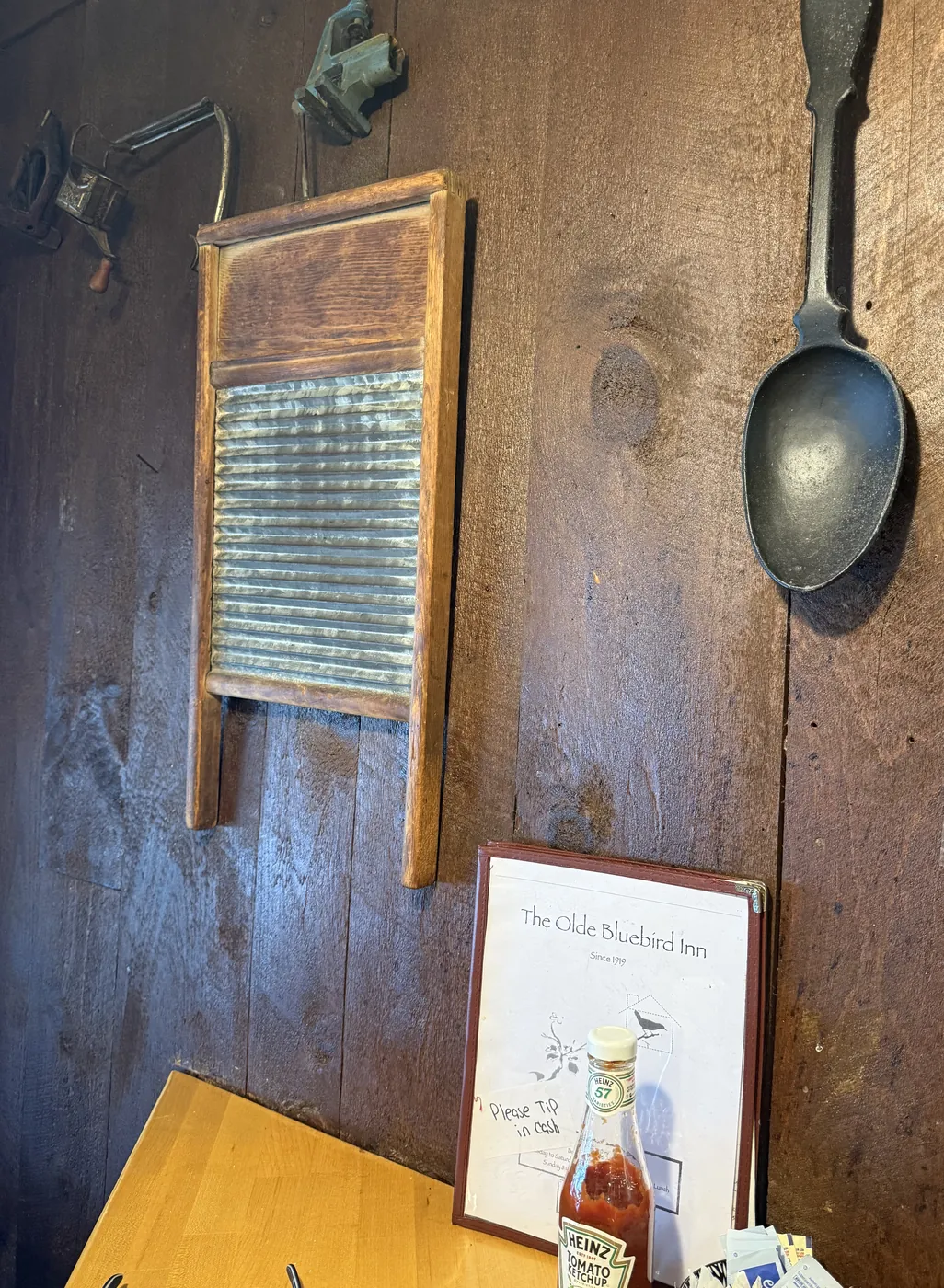 A wooden washboard and an oversized cast-iron spoon mounted on the dining room wall